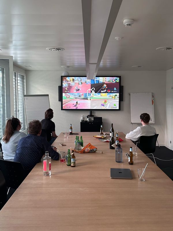 Das Team von Helga spielt im Sitzungszimmer am grossen Screen Mariokart.